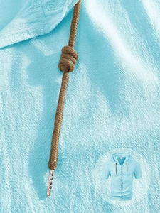 Detailed macro view of light blue linen fabric texture and brown drawstring on hoodie