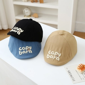 Close-up of three kids caps in black, blue, and khaki with cute bear cartoon embroidery