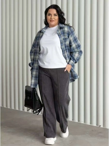 Detail of oversized plaid shirt paired with white tee and grey wide-leg trousers