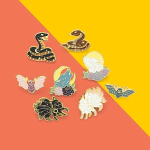 Emaille-Pins-Set mit Motiven von Schlangen, Füchsen und Fledermäusen auf buntem Hintergrund