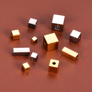Macro shot of gold and silver stainless steel geometric square spacer beads for DIY jewelry