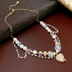 Macro shot of layered pearl and crystal heart pendant necklace on dark wood