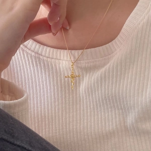 French style 925 silver golden rose cross necklace worn by model on beige background