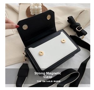 Detail view of the open black and white contrast crossbody bag with double magnetic closures