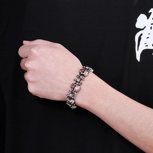 Detail of a vintage skull bracelet with red crystal eyes worn on wrist by a model