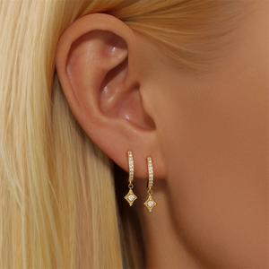 Close-up of S925 sterling silver golden bee earrings with zircon on a model ear