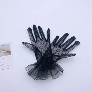 Close-up of elegant black floral lace gloves with double-layered ruffled cuffs and vintage style