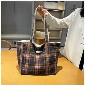 Detail of dark brown plaid tote bag with Magic Pocket label in a modern home setting