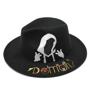 Detail of black fedora hat featuring gold Demon embroidery and silver silhouette print