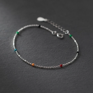 Macro shot of silver chain bracelet featuring vibrant multi-colored small round beads