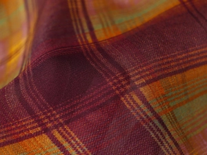 Vue macro de la texture du tissu à carreaux orange et rouge avec détails de tissage