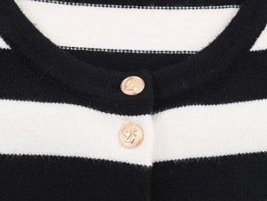 Detail of nautical anchor gold buttons on a classic black and white striped knit cardigan