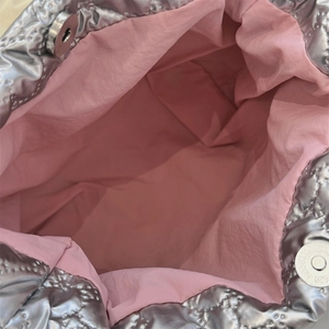 Dettaglio della borsa trapuntata argento con fodera rosa e chiusura a scatto magnetico