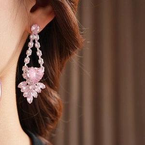 Gros plan de boucles d'oreilles pendantes de luxe en cristal rose sur un mannequin