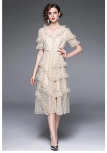 Détail de la dentelle florale sur robe abricot avec ceinture de perles et jupe à volants