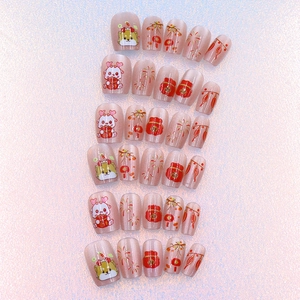 Flat lay of cat-eye pink press-on nails featuring New Year icons like lanterns and puppies