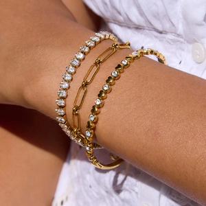 Gold layered heart bracelet set with zircon stones and clip chain on model wrist
