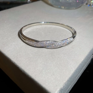 Détail macro d'un bracelet vague argenté avec sertissage micro-pavé de diamants brillants