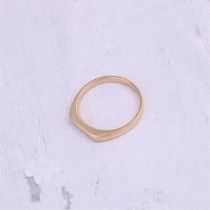 Close-up of geometric flat top ring in 18K gold plated stainless steel on grey background