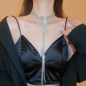 Détail du collier choker avec nœud papillon, glands brillants et perles sur modèle