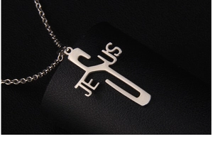 Close-up of a polished stainless steel Jesus cross pendant on a thin silver link chain