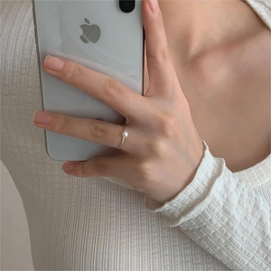 Detailed mirror selfie showing a minimalist S925 sterling silver ring with a white pearl