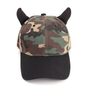Close-up of camouflage baseball cap featuring 3D black devil horns and a flat black brim