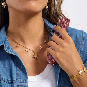 Close-up of model wearing celestial 18K gold stainless steel jewelry set with sun motifs