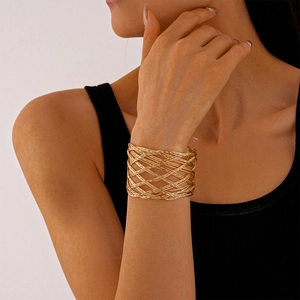 Macro detail of golden woven mesh hollow metal bangle with intricate texture