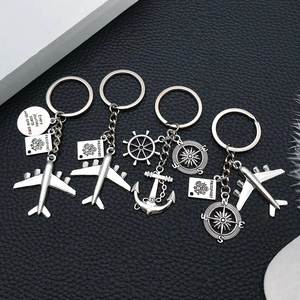 Detailed view of silver metal travel keychains with airplane and passport charms