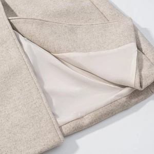 Close-up of beige wool coat fabric showing texture and high-quality white inner lining