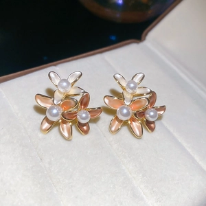 Detail of flower earrings with pink gradient petals and white pearls in a jewelry box