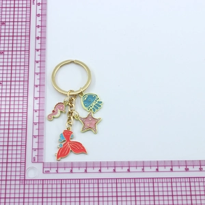 Macro detail of nautical keychain featuring colorful enamel seahorse, starfish, and jellyfish
