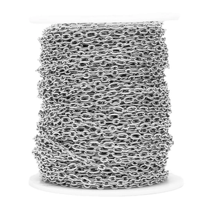 Detailed close-up of a silver stainless steel textured cross chain on a white spool