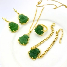 Detailed view of green Buddha charms on gold-plated necklace, bracelet, and earrings set