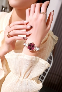 Détail du bracelet de montre en céramique or rose avec cadran bordeaux et calendrier