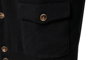 Detail of premium black knit cardigan showing amber texture buttons and pocket stitching