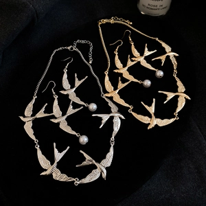 Detailansicht der silbernen und goldenen Schwalben-Schmucksets mit Kunstperlen