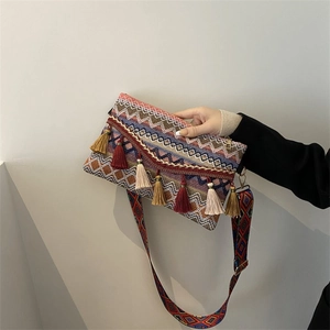 Detail of colorful woven shoulder bag with ethnic geometric patterns and fringe tassels