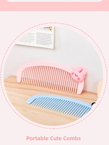 Close-up of cute pink bunny and blue plastic wide-tooth combs on a wooden table
