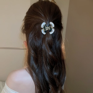 Vista dettagliata dell'elegante molletta per capelli a farfalla con zirconi su capelli mossi