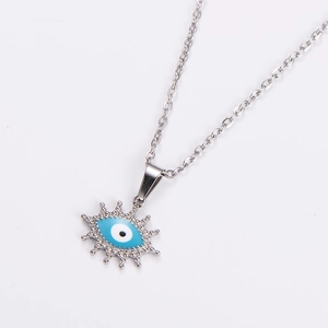 Macro detail of silver stainless steel chain with evil eye pendant and crystal accents