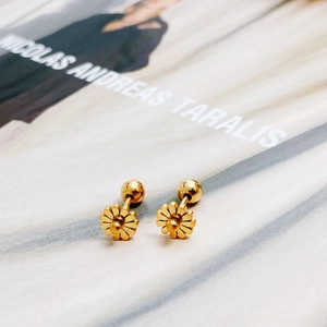 Pair of delicate gold daisy titanium steel stud earrings on a minimalist background