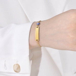 Gold stainless steel evil eye bracelet with customizable rectangle plate on model
