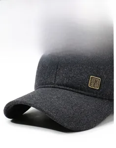 Detailed close-up of dark grey wool fabric and metal emblem on the men baseball cap