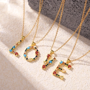 Colorful zircon initial pendant necklaces in gold finish spelling LOVE on stone base