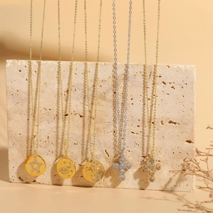 Detailed shot of five 14K gold plated necklaces with zircon pendants on stone background