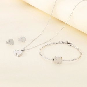 Silver elephant jewelry set with necklace bracelet and earrings on textured surface