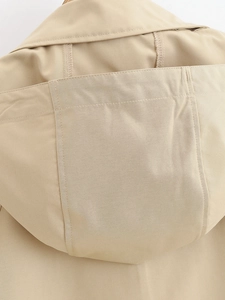 Macro detail of khaki hooded trench coat showing twill fabric texture and stitching