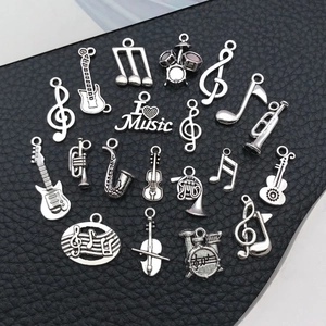 Detailed collection of 19 vintage silver music instrument and note pendants on leather